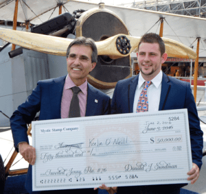 Don Sundman presenting reward check to the man who found the Inverted Jenny, Keelin O’Neil.